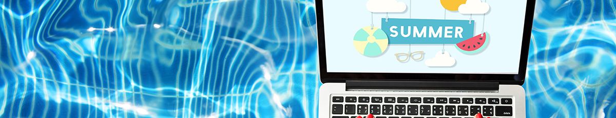 a student sits by the pool on a laptop 