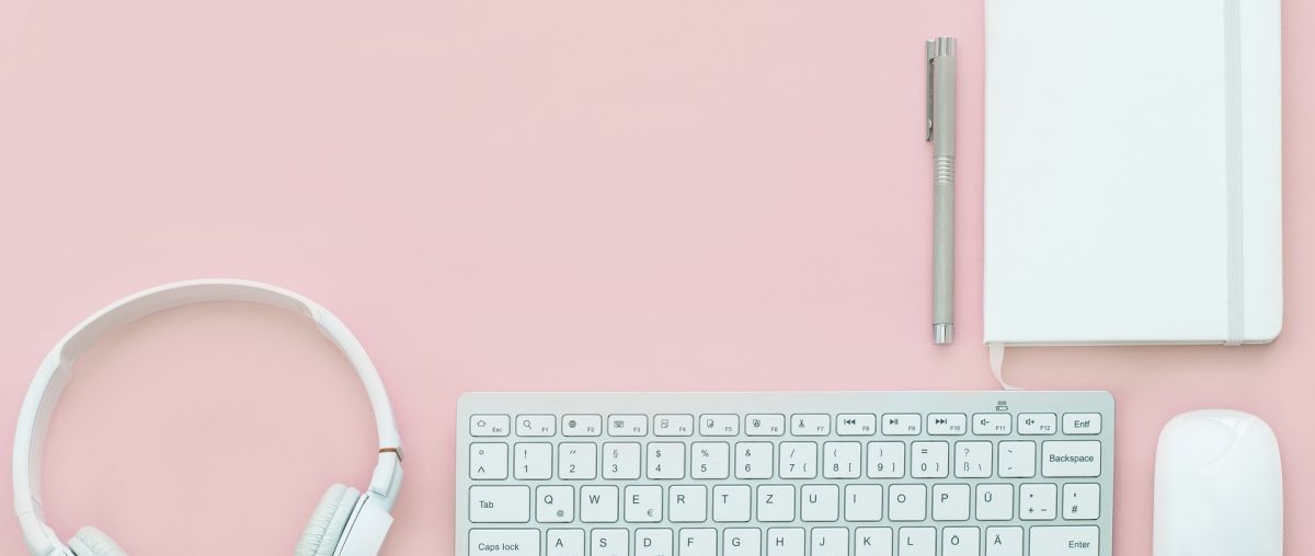 headphones, keyboard, mouse, and paper on a desk