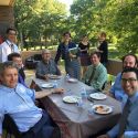 10 FET members sitting at a table and standing outdoors eating