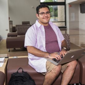 Male student working on laptop in Collins Hall