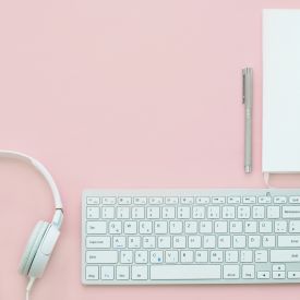 headphones, keyboard, mouse, and paper on a desk