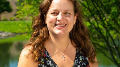 Jeannie Anderson in front of lake at Waubonsee, medium length brown hair